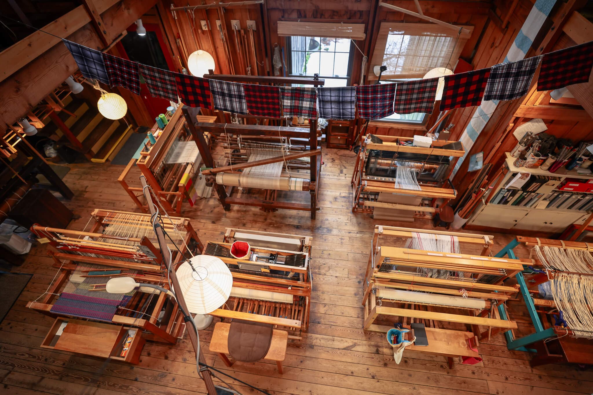 An overhead view of weaving looms in a craft school.